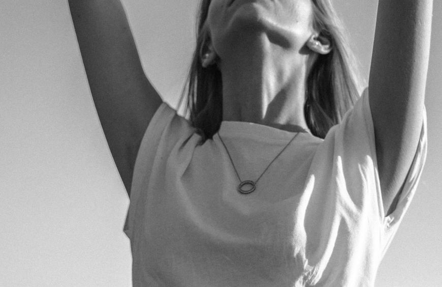 Woman in t-shirt with arms raised